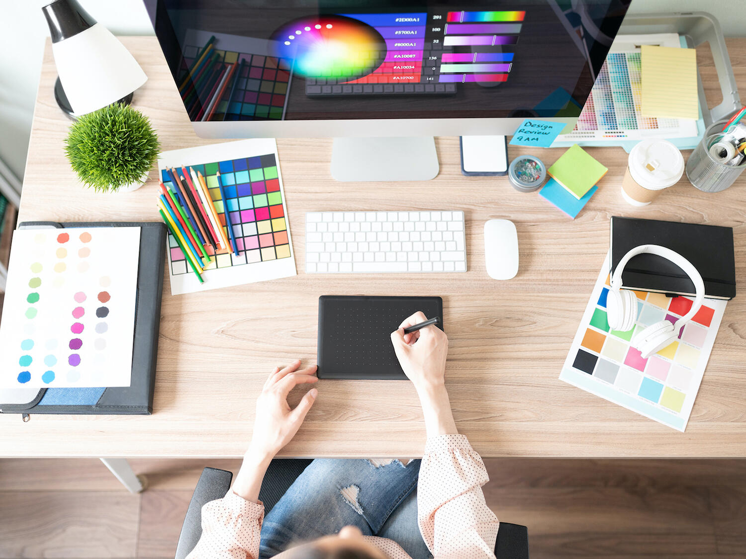 Bird's eye view of a graphic designer working at their desk.